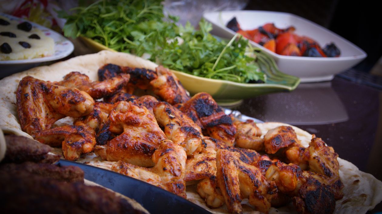 Grilled chicken wings served with fresh herbs and vegetables at Roma Pizza Donair